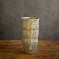 Handmade slender teacup by Master Yiwen, Yunnan clay with natural wood-fired ash glaze.