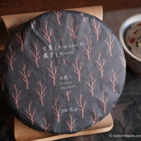 pu'er tea cake from nannuo mountain, Yunnan, 2008 harvest vintage aged, on bamboo tripod with hand painted gaiwan