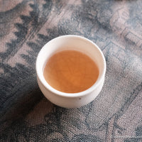 pu'er shengpu tea cake and brick from nannuo mountain, Yunnan, 2008 harvest vintage aged, brewed in white ceramic cup