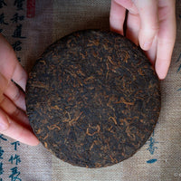 Detail of cake of pu'er shupu tea in pressed cake brick, fermented, from Yiwu mountain and ancient trees high quality tea