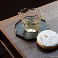 pu'er shengpu cake pressed brick from ancient trees gushu, autumn harvest 2021, from Yunnan, China, transparent liquor in glass container pitcher