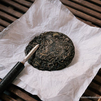 Pu'er shengpu ancient trees gushu in pressed cake, from Yunnan, China, with bamboo tray. 2021 spring harvest vintage