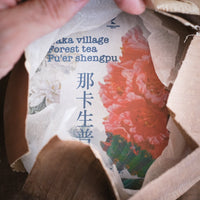 forest pu'er tea from Naka village, Yunnan, China, stone-pressed for collection, shengpu in bamboo tong