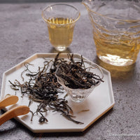 Pu'er shengpu Chinese tea loose-leaf vintage and aged, 2017 spring harvest, from ancient trees forest, yellow brew liquor in glass cup, golden buds, from Nannuo in Yunnan
